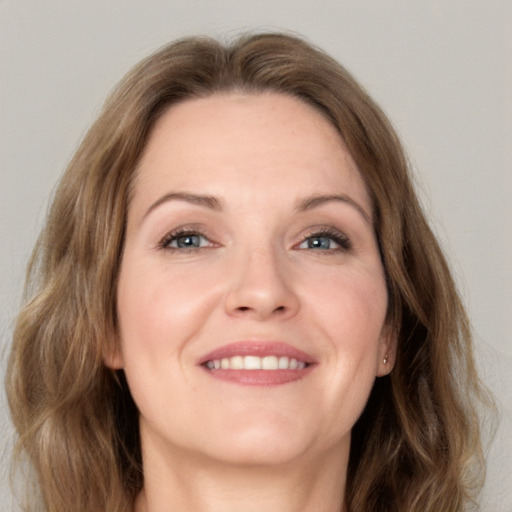 Joyful white adult female with medium  brown hair and grey eyes