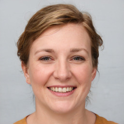 Joyful white adult female with medium  brown hair and grey eyes