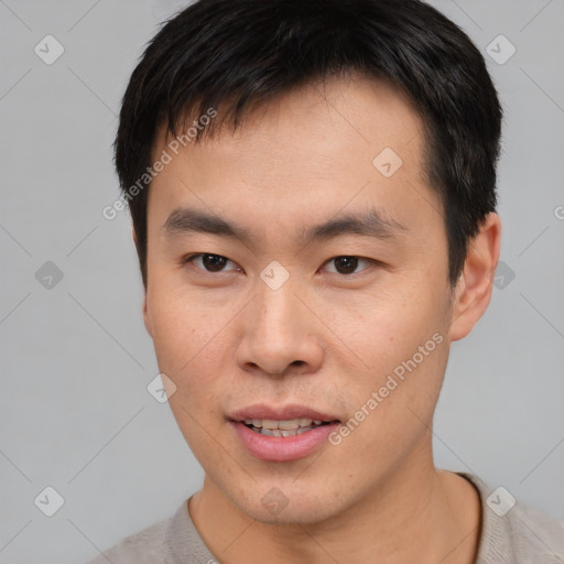 Joyful asian young-adult male with short  brown hair and brown eyes