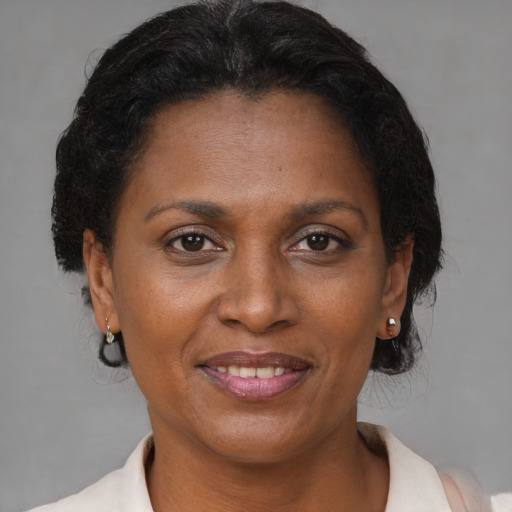 Joyful black adult female with short  brown hair and brown eyes