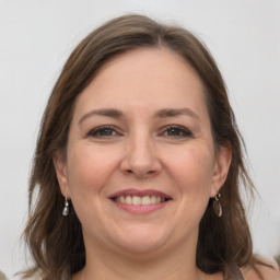 Joyful white adult female with medium  brown hair and grey eyes