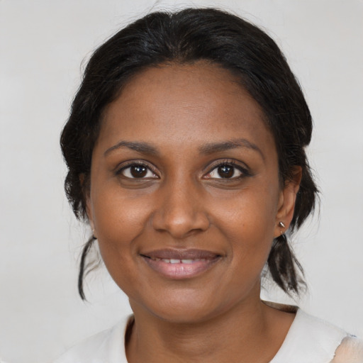 Joyful black adult female with medium  brown hair and brown eyes
