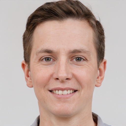 Joyful white adult male with short  brown hair and grey eyes