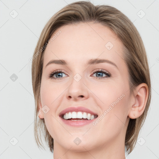 Joyful white young-adult female with medium  brown hair and blue eyes