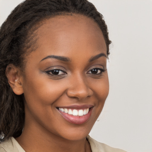 Joyful black young-adult female with long  brown hair and brown eyes