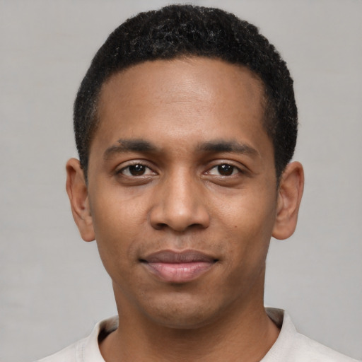 Joyful black young-adult male with short  black hair and brown eyes