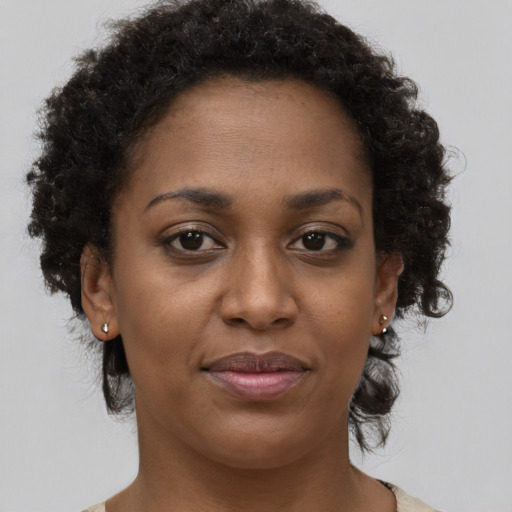 Joyful black adult female with short  brown hair and brown eyes