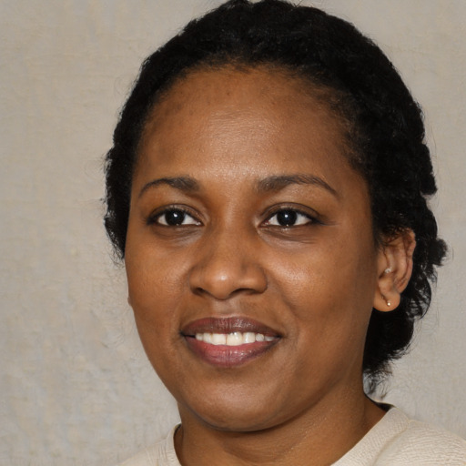 Joyful black young-adult female with short  brown hair and brown eyes