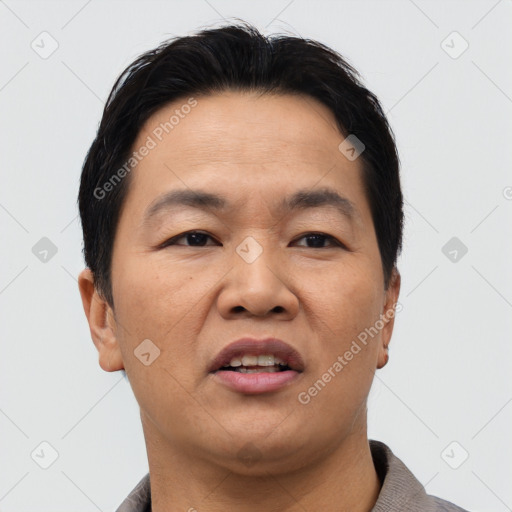 Joyful asian adult male with short  brown hair and brown eyes