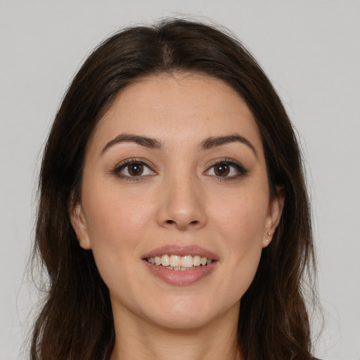 Joyful white young-adult female with long  brown hair and brown eyes