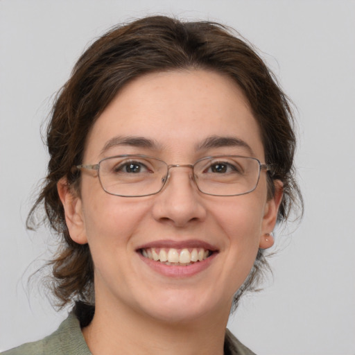 Joyful white adult female with medium  brown hair and green eyes