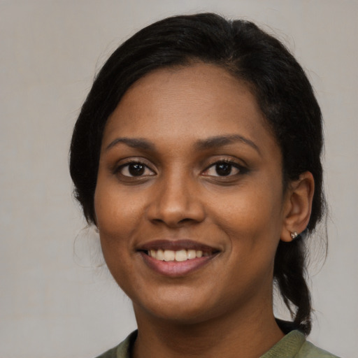 Joyful black young-adult female with medium  black hair and brown eyes