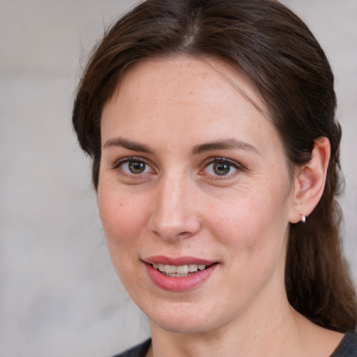 Joyful white adult female with medium  brown hair and grey eyes