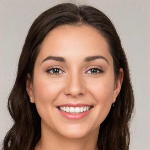 Joyful white young-adult female with long  brown hair and brown eyes