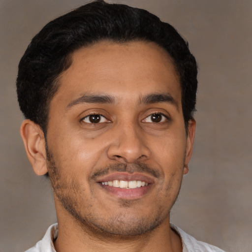 Joyful latino young-adult male with short  brown hair and brown eyes