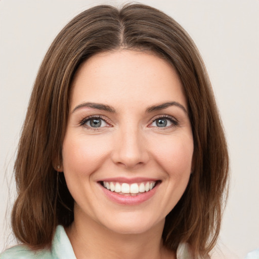 Joyful white young-adult female with medium  brown hair and green eyes