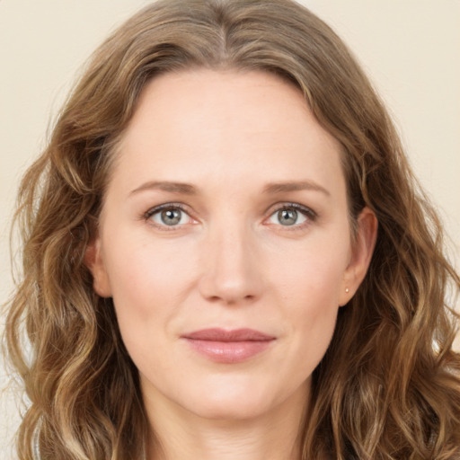 Joyful white young-adult female with long  brown hair and blue eyes