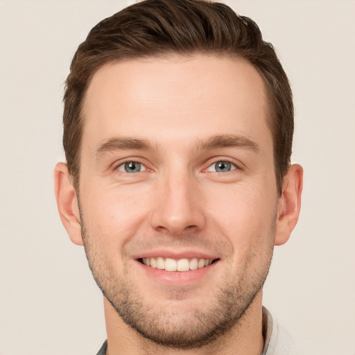 Joyful white young-adult male with short  brown hair and grey eyes