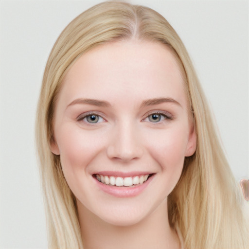 Joyful white young-adult female with long  brown hair and blue eyes