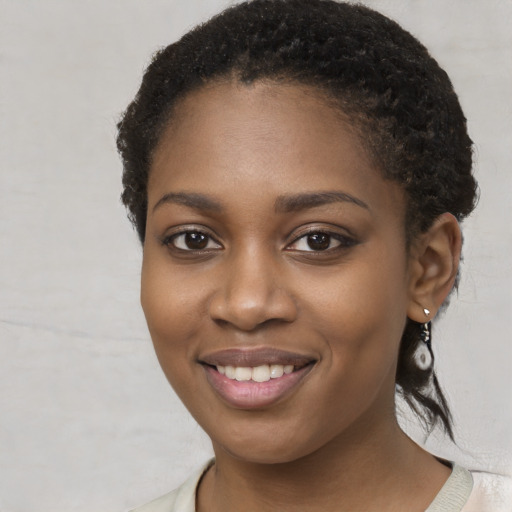 Joyful black young-adult female with short  brown hair and brown eyes