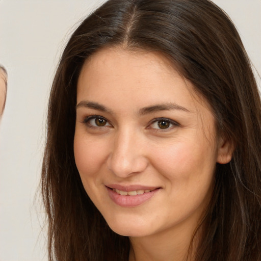 Joyful white young-adult female with long  brown hair and brown eyes