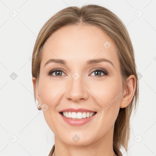 Joyful white young-adult female with medium  brown hair and grey eyes