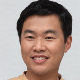 Joyful asian young-adult male with short  brown hair and brown eyes