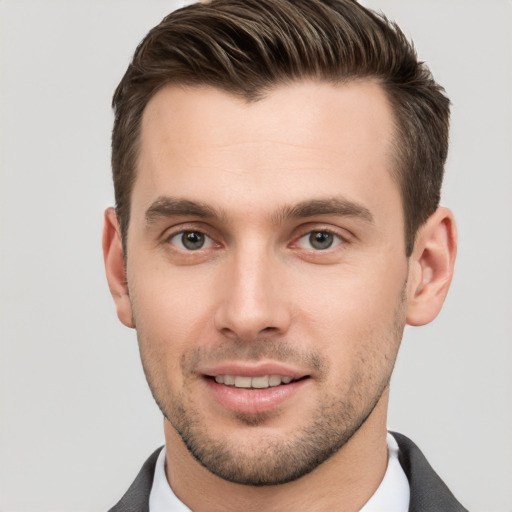 Joyful white young-adult male with short  brown hair and grey eyes