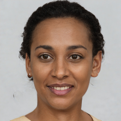 Joyful black young-adult female with short  brown hair and brown eyes