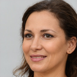 Joyful white adult female with long  brown hair and brown eyes