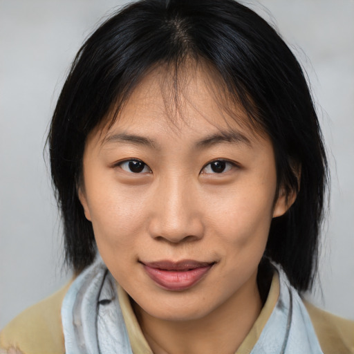 Joyful asian young-adult female with medium  brown hair and brown eyes