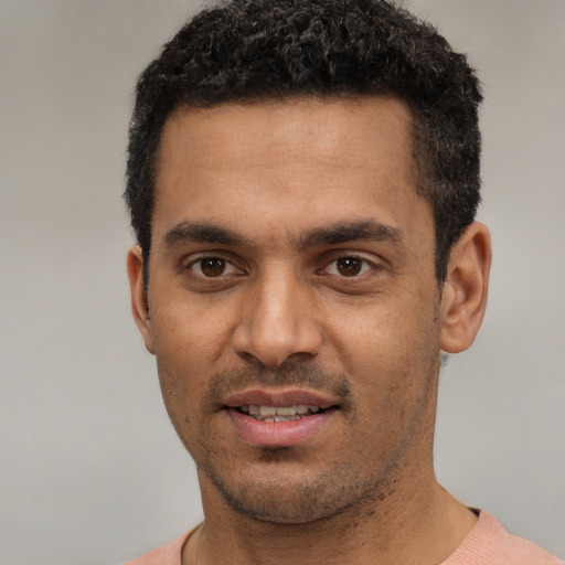 Joyful white young-adult male with short  black hair and brown eyes