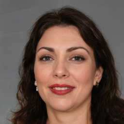 Joyful white adult female with long  brown hair and brown eyes