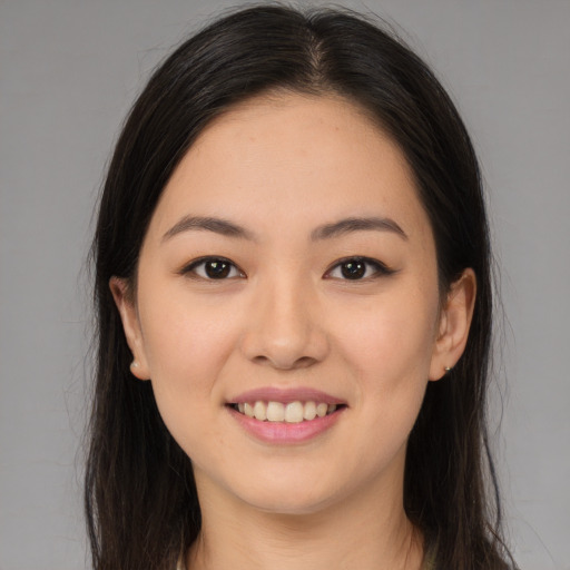 Joyful asian young-adult female with long  brown hair and brown eyes