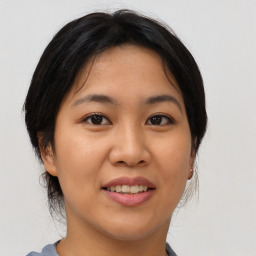 Joyful asian young-adult female with medium  brown hair and brown eyes