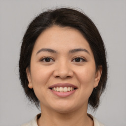 Joyful asian young-adult female with medium  brown hair and brown eyes