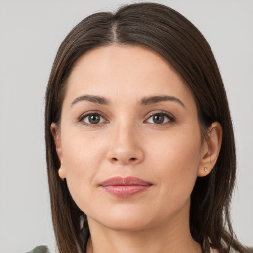 Joyful white young-adult female with long  brown hair and brown eyes