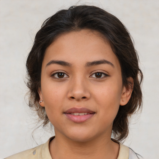 Joyful latino young-adult female with medium  brown hair and brown eyes