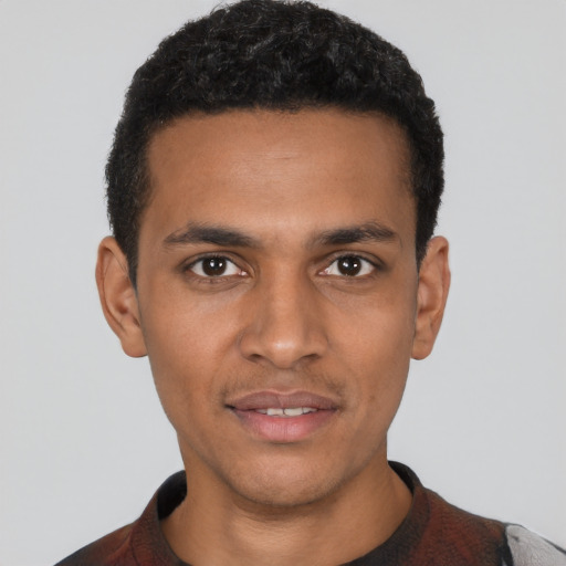 Joyful black young-adult male with short  black hair and brown eyes