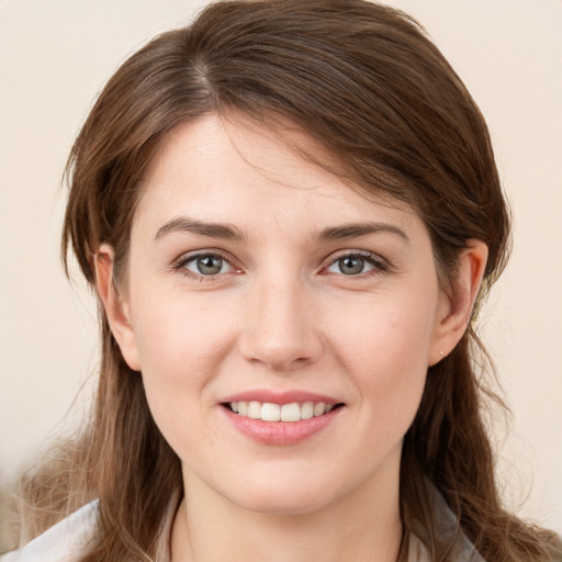 Joyful white young-adult female with medium  brown hair and grey eyes