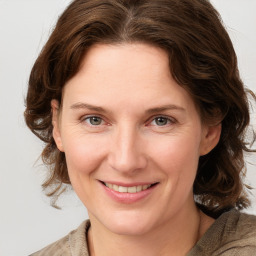 Joyful white young-adult female with medium  brown hair and grey eyes