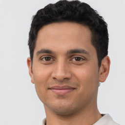 Joyful latino young-adult male with short  brown hair and brown eyes