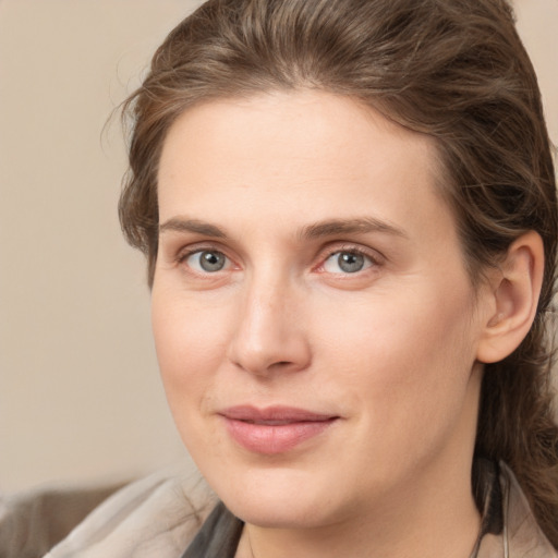 Joyful white young-adult female with medium  brown hair and grey eyes