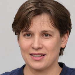 Joyful white adult female with medium  brown hair and grey eyes