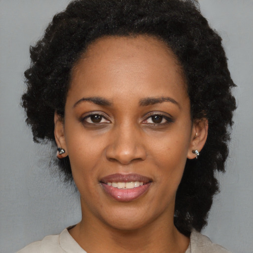 Joyful black adult female with medium  black hair and brown eyes