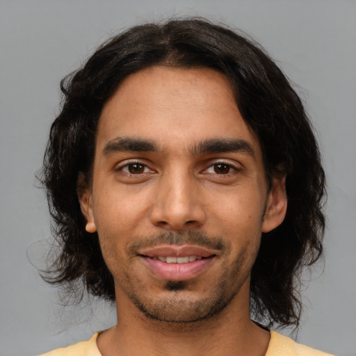 Joyful latino young-adult male with short  black hair and brown eyes
