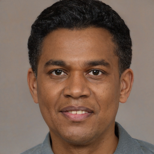 Joyful latino adult male with short  black hair and brown eyes