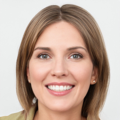 Joyful white young-adult female with medium  brown hair and green eyes