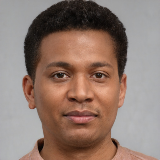 Joyful black young-adult male with short  brown hair and brown eyes