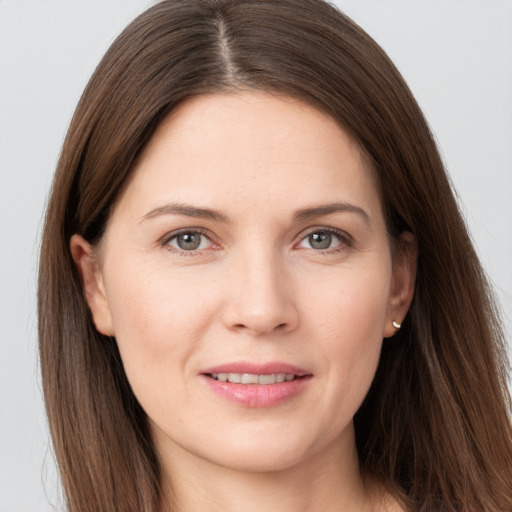 Joyful white young-adult female with long  brown hair and grey eyes